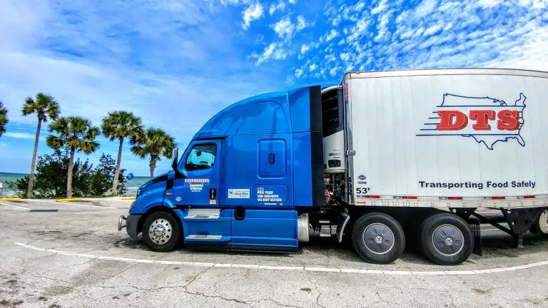 A DTS semi tractor and trailer combo parked alongside the beach in Florida.